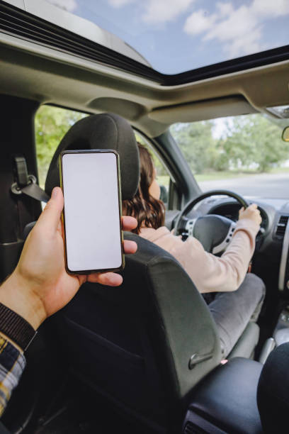 istock man hand holding phone with white screen woman driving car 1285759733