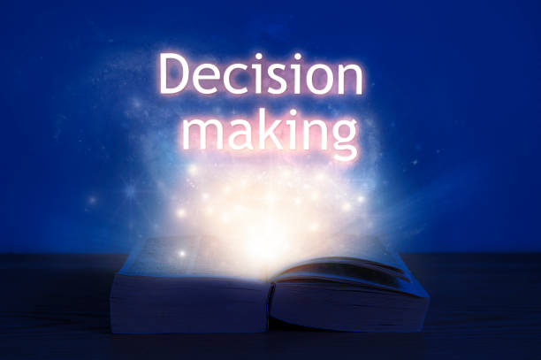 istock Open book with decision making inscription. Light coming from open book with words decision making. 1285761959