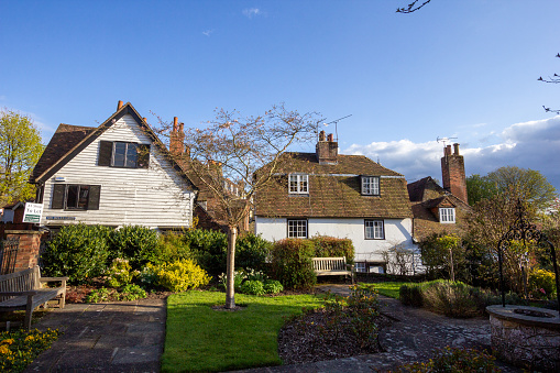 Upper High Street Gardens in Sevenoaks, England, with houses and shops visible in the background in Six Bells Lane. A letting sign is visible in the distance.