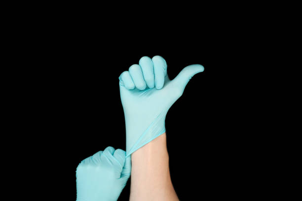 istock Hand in blue glove isolated on black with thumb up. 1285763466