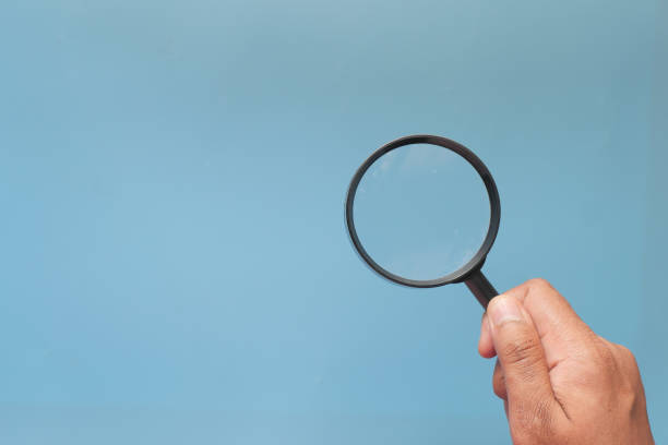 istock hand holding magnifying glass on color background 1285764060