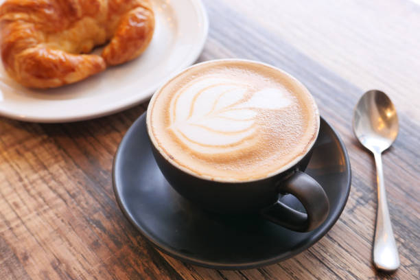 istock Coffee and croissant on wooden table, top view . 1285764236