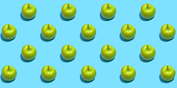 istock Fruit pattern of fresh green apples on blue background. Top view. Summer concept. Collage 1285765427