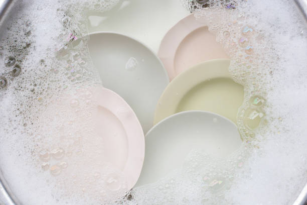 istock Washing dishes, Close up of utensils soaking in kitchen sink. 1285765458