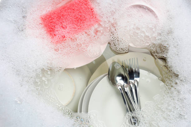 istock Washing dishes, Close up of utensils soaking in kitchen sink. 1285765557