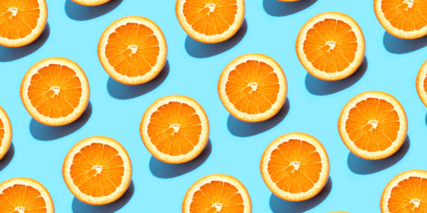 istock Fruit pattern of fresh orange slices on blue background. Top view. Summer concept. Collage 1285765659