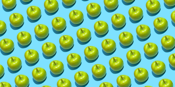 istock Fruit pattern of fresh green apples on blue background. Top view. Summer concept. Collage 1285765672