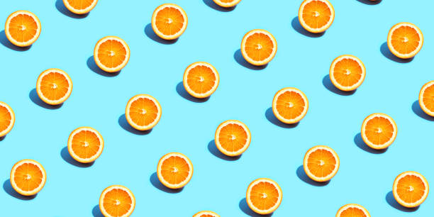 istock Fruit pattern of fresh orange slices on blue background. Top view. Summer concept. Collage 1285765691