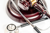 Judge's mallet next to stethoscope on a white background SELECTIVE FOCUS.