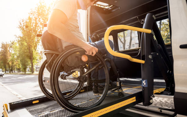 un uomo su una sedia a rotelle su un ascensore di un veicolo per le persone con disabilità - tipo di trasporto foto e immagini stock