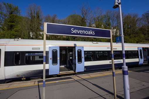 Sevenoaks Rail Station in Kent, England, with a train in the background waiting for passengers to get on