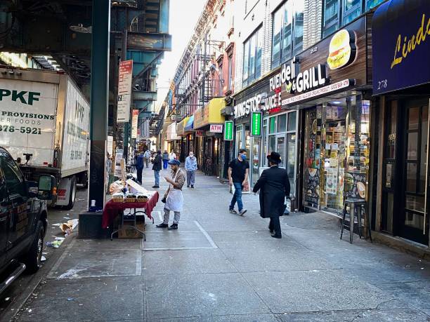 Broadway (Brooklyn) sidewalk view Brooklyn, NY, USA - Nov 15, 2020: People shopping along the sidewalk under the J,M,Z elevated subway line warren street brooklyn stock pictures, royalty-free photos & images