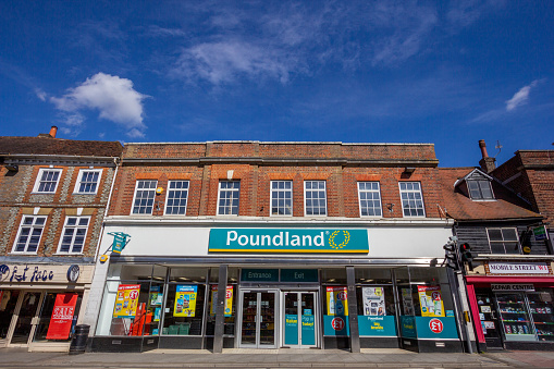 Poundland in Sevenoaks, England. This is a UK chain store selling various items at £1. It was founded in 1990. Other stores can be seen alongside.