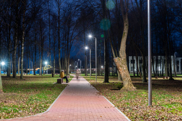 istock Park landscape with a bench, footpath and night lighting. 1285773604
