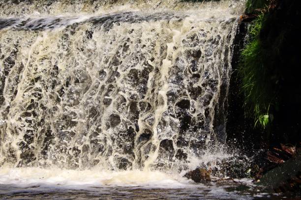 istock water stream cascade falling on the rocks close up 1285773696