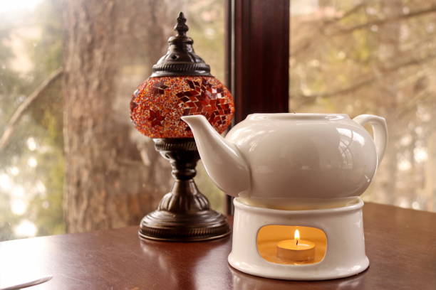 istock orange lamp and a white teapot with a burning candle under it on the table 1285774454