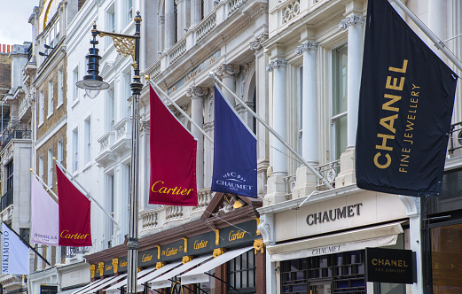 London, UK - August 13, 2019: Old Bond street view with flags of famous fashion houses. Bond Street is a major shopping street in the West End of London for luxury designer brands