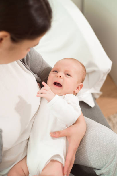 istock a small baby cries in her mother s arms 1285777571