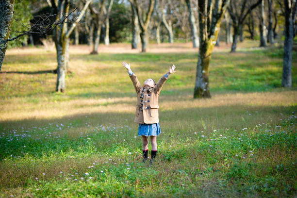 istock Girl opens arms in the autumn forest 1285777822