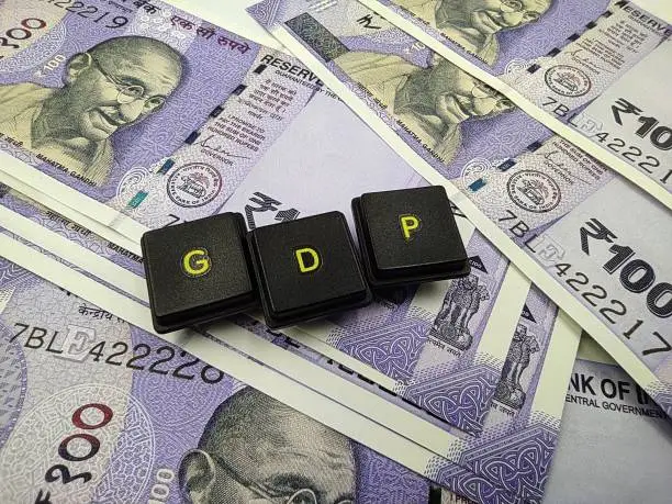 Photo of indian currency and gdp word spelled out