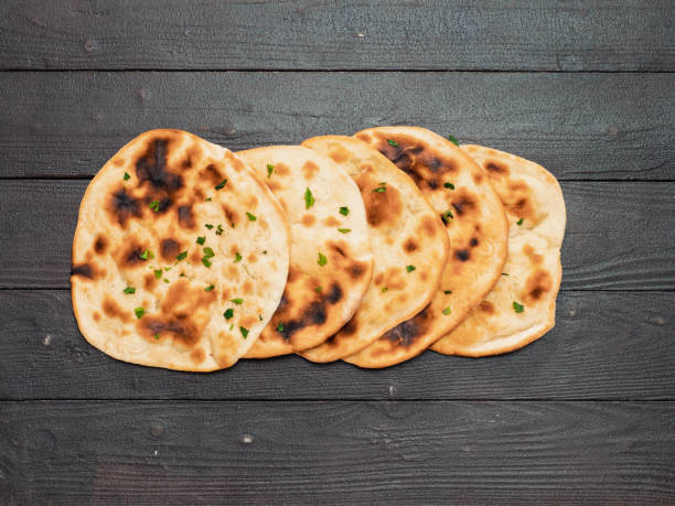 istock naan flatbreads on dark wood, copy space, top view 1285781486