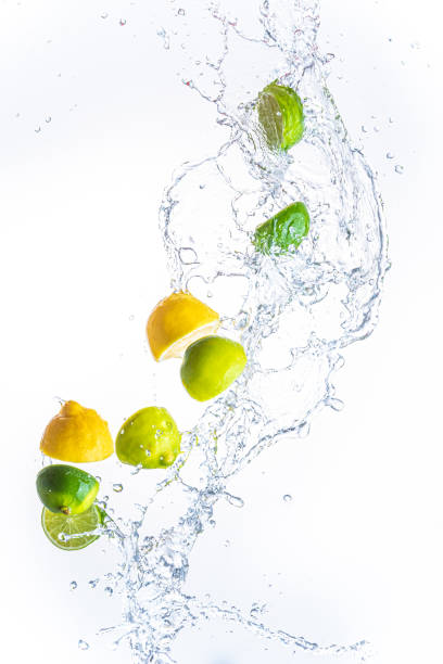 istock Fresh limes and lemons with water splash in midair, isolated on white background 1285781592