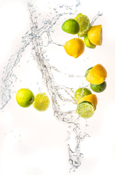 istock Fresh limes and lemons with water splash in midair, isolated on white background 1285781596