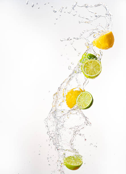 istock Fresh limes and lemons with water splash in midair, isolated on white background 1285781598