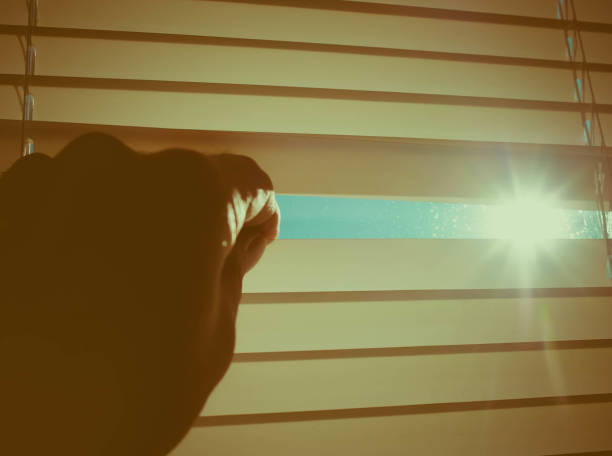 istock The sun shines through the half-open blinds on the window. 1285781827