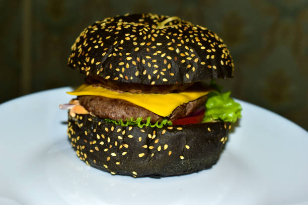 istock Black hamburger with meat and vegetables close-up 1285782023