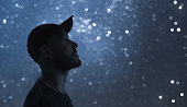 Night portrait. A man in profile. Starry sky bokeh in background.