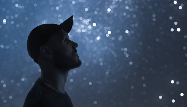 Night portrait. A man in profile. Starry sky bokeh in background. Night portrait. A man in profile. Starry sky bokeh in background astronomy stock pictures, royalty-free photos & images