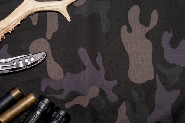 istock Hunting background. On camouflage background flat lay with hunting accessories. Top view with place for text 1285782817