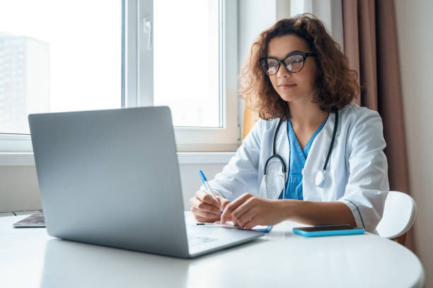 Female doctor wear white medical robe make online video call consult patient. stock photo