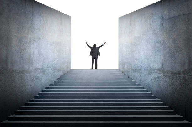 istock Man Standing With Arms Raised At Top Of Steps 1285784117