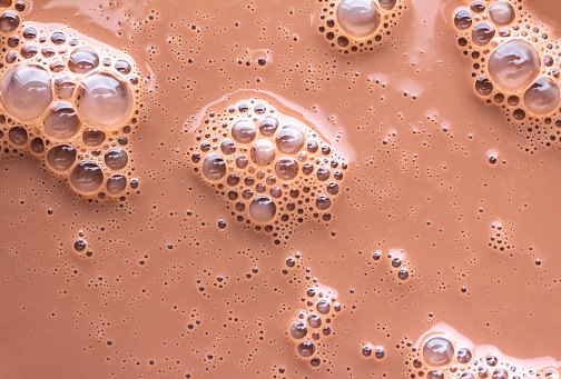 Bubbles are floating on the surface of chocolate milk
