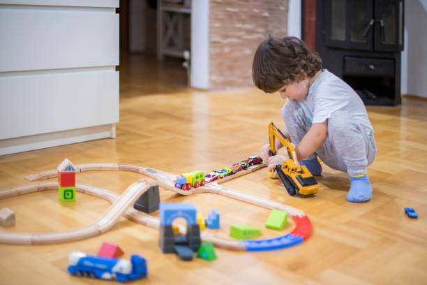 istock Beautiful little boy playing with a railroad train toy. 1285788495
