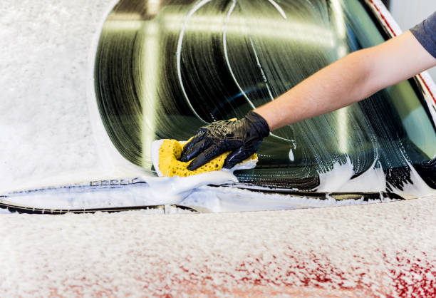 istock Worker washing red car with sponge on a car wash 1285788533
