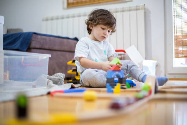 istock Beautiful little boy playing with a railroad train toy. 1285788538