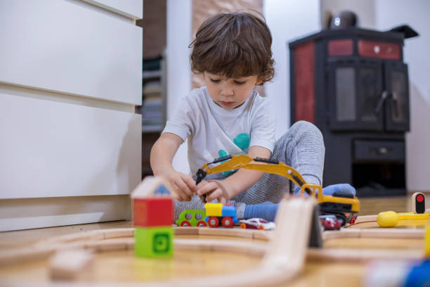 istock Beautiful little boy playing with a railroad train toy. 1285788543