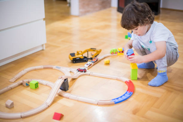 istock Beautiful little boy playing with a railroad train toy. 1285788571