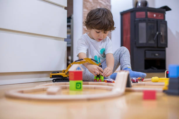 istock Beautiful little boy playing with a railroad train toy. 1285788943