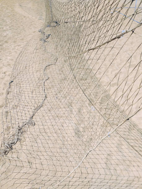 istock Fall beach volleyball net background. Beach sport net on white sand pattern. Lack of maintenance of sports equipment concept. 1285789177