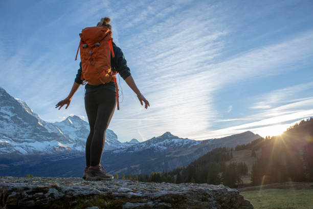 istock Female hiker relaxes on mountain ridge at sunrise 1285790153