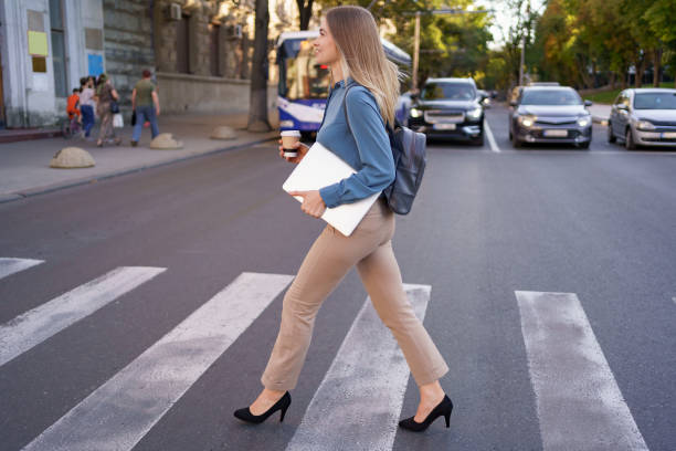 istock Woman passing zebra with coffee and laptop 1285791401