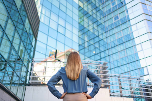 istock Back view woman looking business building 1285791419