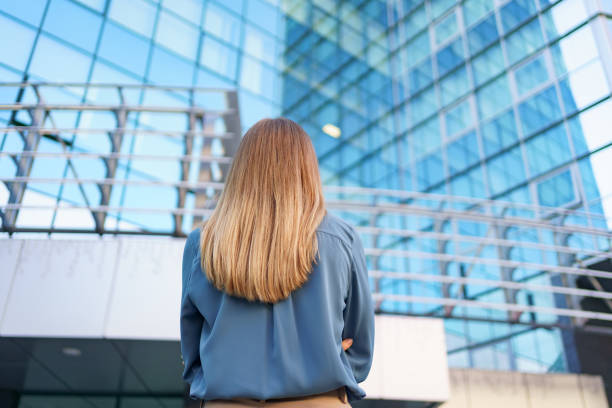 istock Back view woman looking business building 1285791425