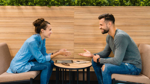 istock Two 30s colleagues sitting and drinking coffee together in office cafeteria 1285791746