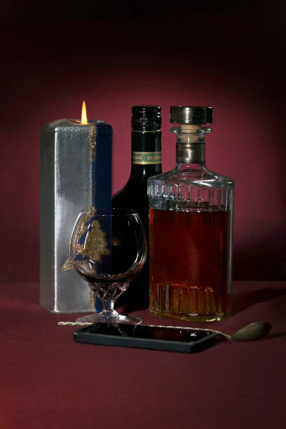 istock Still life with alcohol bottels, glass and candle stick 1285791847