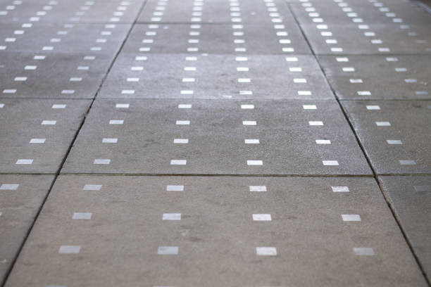 a pathway in a city paved with concrete blocks and decorated with metal squares